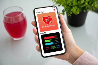 tablonun üst kısmındaki kafede ekranda dokunmatik telefon app kalp ve aktivite tutan el