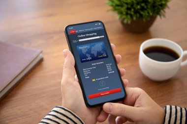 tablonun üst kısmındaki ofiste ekranda app online alışveriş ile dokunmatik telefon tutarak el