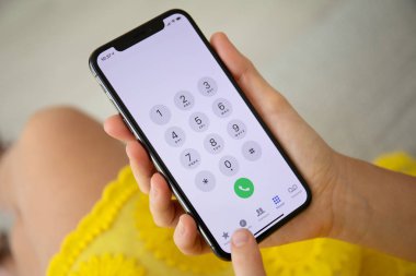Aluşta, Rusya - 27 Eylül 2018: kadın el iphone X yer numarası ile ekran üzerinde tutarak. iPhone 10 oluşturuldu ve Apple Inc tarafından geliştirildi.