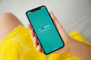 Aluşta, Rusya - 27 Eylül 2018: sosyal ağ hizmeti Tripadvisor üstünde belgili tanımlık perde ile iphone X tutan kadın. iPhone oluşturuldu ve Apple Inc tarafından geliştirildi.
