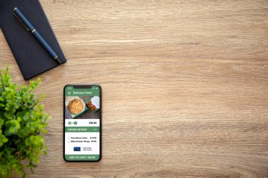 Telefon app teslim gıda ekran ve bir dizüstü bilgisayar ile ahşap masa ile
