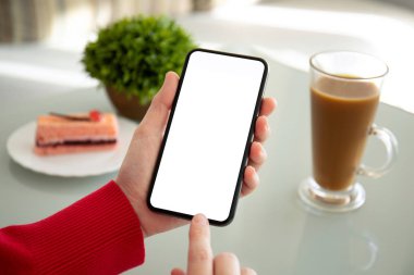 bir kafede telefon ile izole perde tablosunun üstünde tutan eller