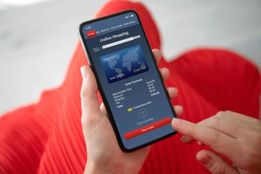 Kırmızı elbiseli telefon app ekranda online alışveriş ile tutan eller