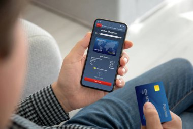 Erkek el telefon app ekran ve bir kredi kartı online alışveriş ile tutarak