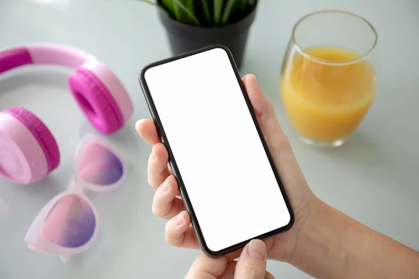 Vrouwelijke Hand Telefoon Met Geïsoleerde Scherm Boven Tabel Met Koptelefoon — Stockfoto