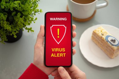 virüs uyarısı alarm kafede tablonun üst ekranda uyarı ile telefon tutarak eller