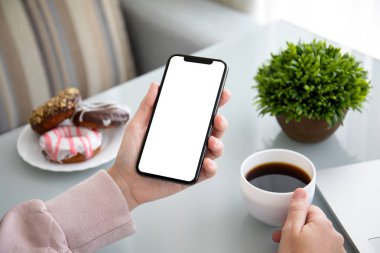 bir kafede telefon ile izole perde tablosunun üstünde tutan eller