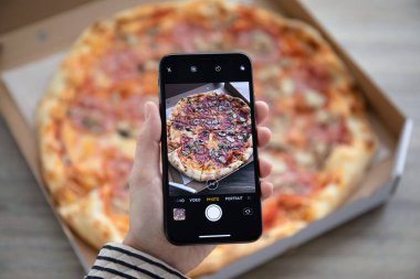 Anapa, Rusya - 24 Eylül 2018: fotoğraf makinesi ekranı pizza teslimat ile iphone X tutan kadın el. iPhone on oluşturuldu ve Apple Inc tarafından geliştirildi.