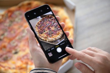 Anapa, Rusya - 24 Eylül 2018: fotoğraf makinesi ekranı pizza teslimat ile iphone X tutan kadın el. iPhone on oluşturuldu ve Apple Inc tarafından geliştirildi.