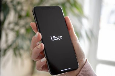 Anapa, Rusya - 20 Şubat 2019: kadın el iphone X uygulaması taksi Uber üstünde belgili tanımlık perde ile tutarak. iPhone 10 oluşturuldu ve Apple Inc tarafından geliştirildi.