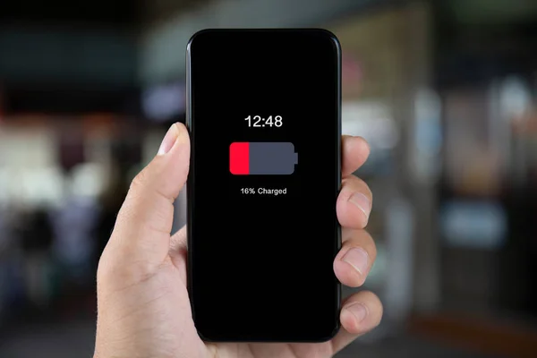 男の手が画面上低充電で携帯電話を保持 — ストック写真
