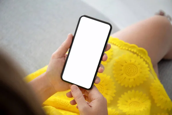 Frauenhände in gelbem Kleid halten Telefon mit isoliertem Bildschirm — Stockfoto