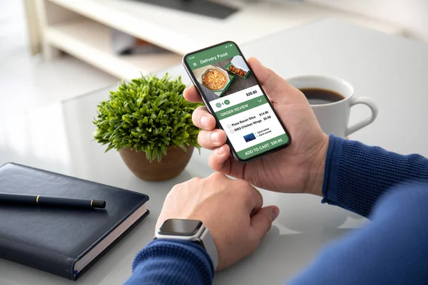 Homme mains montre tenant avec app livraison de nourriture à l'écran — Photo