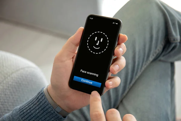 Männliche Hände halten Telefon mit Gesichtserkennung auf dem Bildschirm — Stockfoto