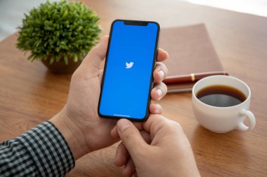 Erkekler el iPhone X sosyal ağ hizmeti Twitter ile tutarak