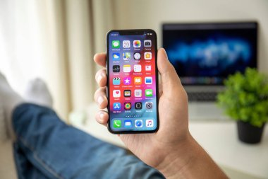 Ana ekran IOS ile iPhone X tutan adam el