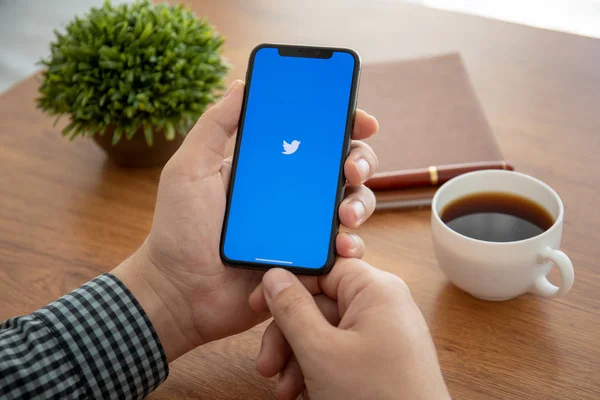 Männer halten iphone x mit sozialen Netzwerk-Dienst Twitter — Stockfoto