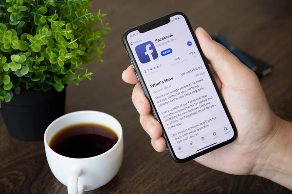 Männer halten iphone x mit sozialen Netzwerk-Dienst facebook — Stockfoto