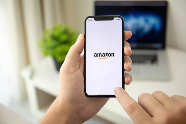 Mann hält iphone x mit Internet-Shopping-Dienst amazon — Stockfoto