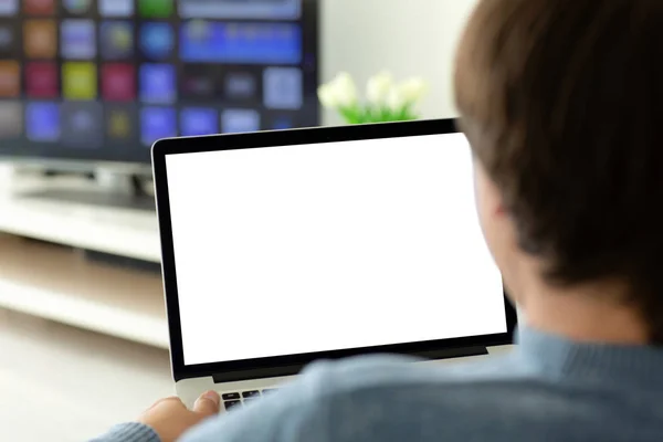 Чоловік тримає ноутбук з ізольованим екраном в кімнаті — стокове фото
