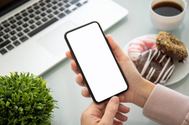 masanın üzerinde izole ekran ile telefon tutan kadın eller