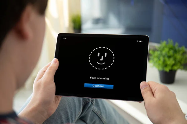 顔IDスキャンでコンピュータタブレットを保持する男の手 — ストック写真