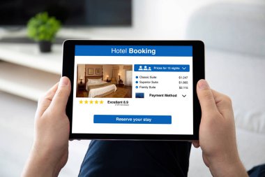 uygulama otel rezervasyonu ile bilgisayar tablettutan adam elleri