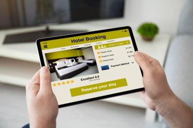 uygulama otel rezervasyonu ile bilgisayar tablettutan adam elleri 