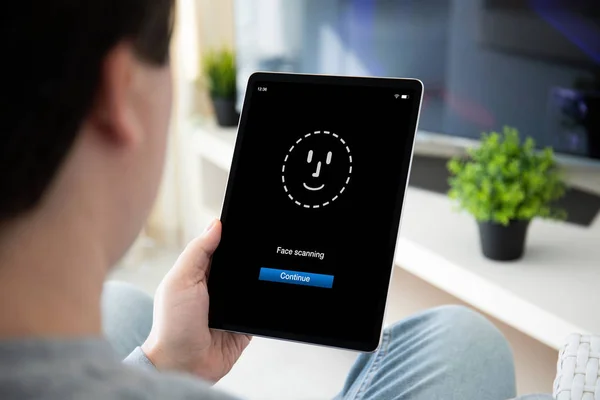 Mann hält Computertablett mit Gesichtserkennung in der Hand — Stockfoto