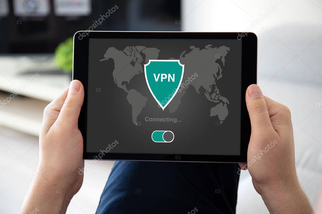 man hands holding computer tablet with app vpn on screen