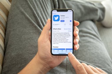 Sosyal ağ hizmeti Twitter ile iPhone X tutan adam el
