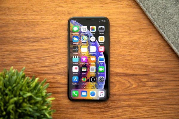 IPhone X з домашнім екраном IOS на столі — стокове фото