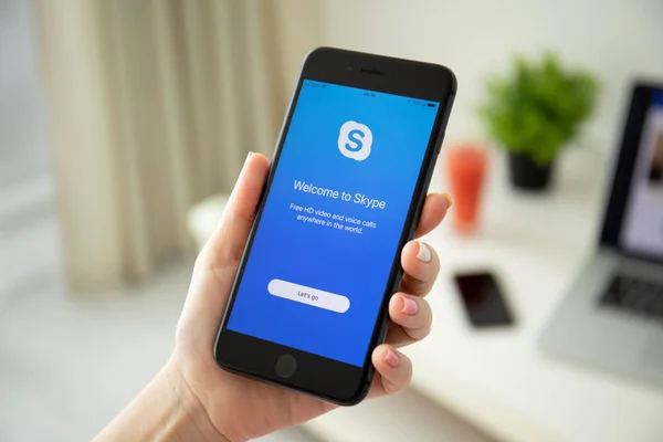 Kvinna hand hållande iPhone 8 plus med yrken Skype applicering — Stockfoto