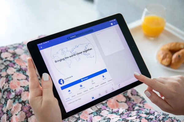 Woman holding iPad Pro with social networking service Facebook — Stock Photo, Image