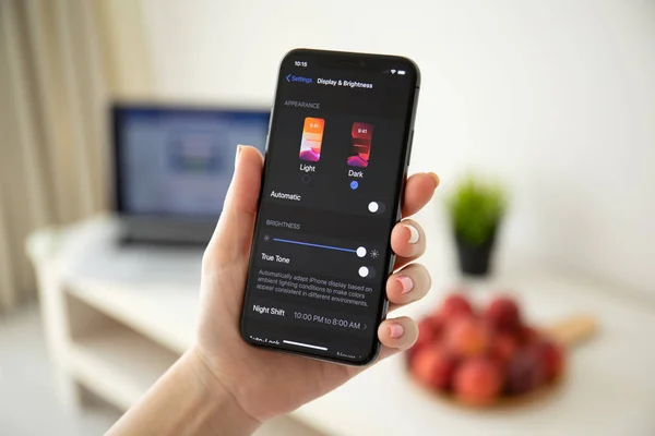 Frau hält iphone x mit ios 13 Dark-Modus. — Stockfoto