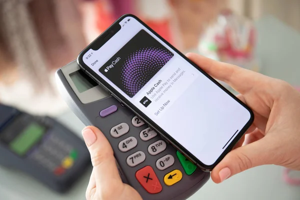 Женщина держит iPhone с Apple Pay Cash и онлайн терминал . — стоковое фото