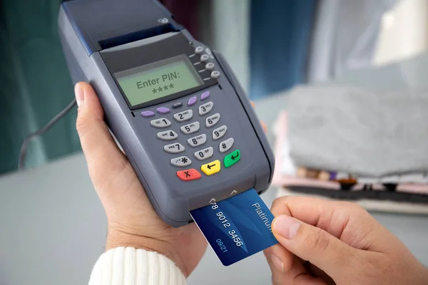 Man hand holding plastic card and pay pass online terminal