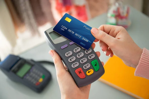 Woman hand holding plastic card and pay pass online terminal — Stock Photo, Image