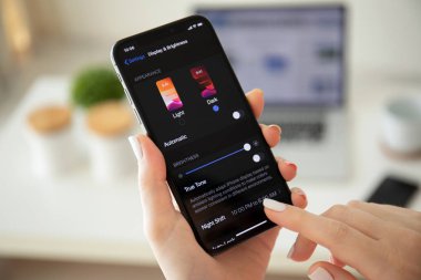 Ios 13 Karanlık Modu ile iphone X tutan kadın el