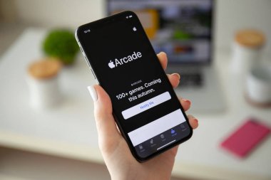 Oyun hizmeti Apple Arcade ile iphone X tutan kadın