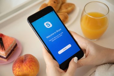 Skype uygulamasını arayarak iphone 8 Plus'ı tutan kadın el ele tutuşuyor