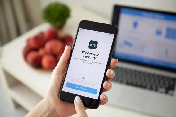 Woman holding iPhone 8 Plus with app Apple TV — Stock Photo, Image