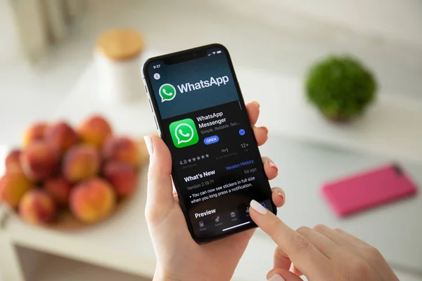 Mujer sosteniendo iPhone X con servicio de redes sociales WhatsApp —  Fotos de Stock