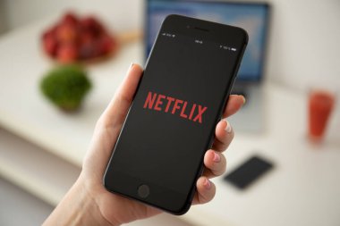 Ekranda Netflix ile iphone 8 Plus tutan kadın.