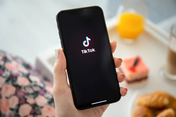 Woman holding iPhone X streaming service media and video TikTok — Stock Photo, Image