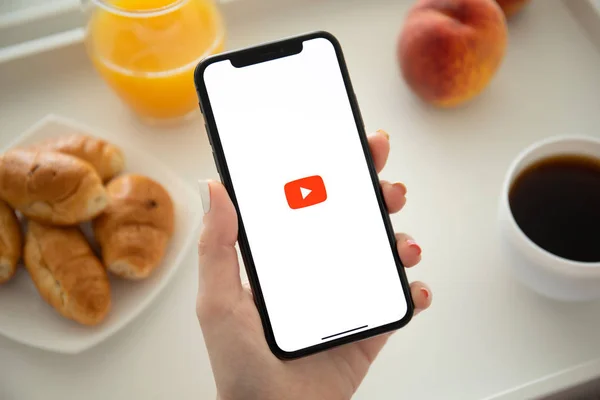 Frau hält iphone x mit app youtube auf dem Bildschirm. — Stockfoto