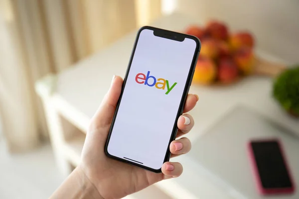 Woman holding iPhone X with Internet shopping service eBay — Stock Photo, Image