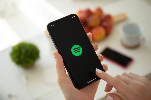 Woman holding iPhone X with music service Spotify on screen. — Stock Photo, Image