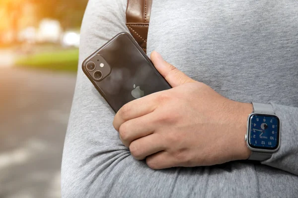 Main d'homme avec Apple Watch Series 5 tenant iPhone 11 — Photo