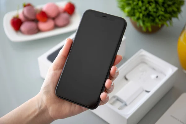 Frau hält Schachtel Apple iphone 11 unter dem Tisch — Stockfoto